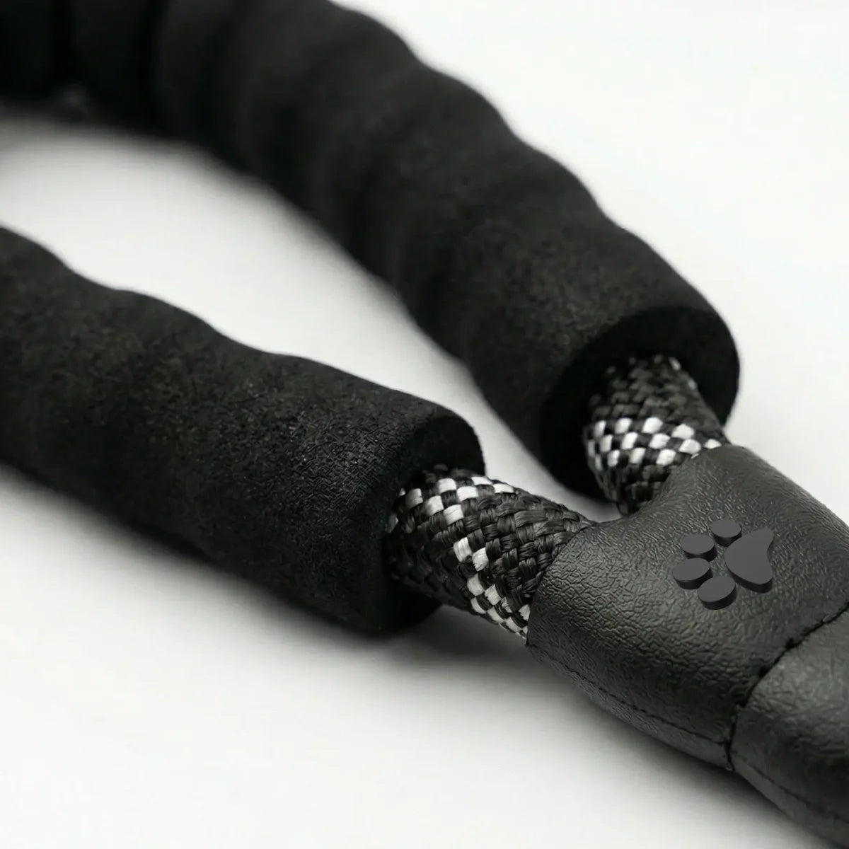 Comfortable padded handle on a black reflective rope leash for better control.